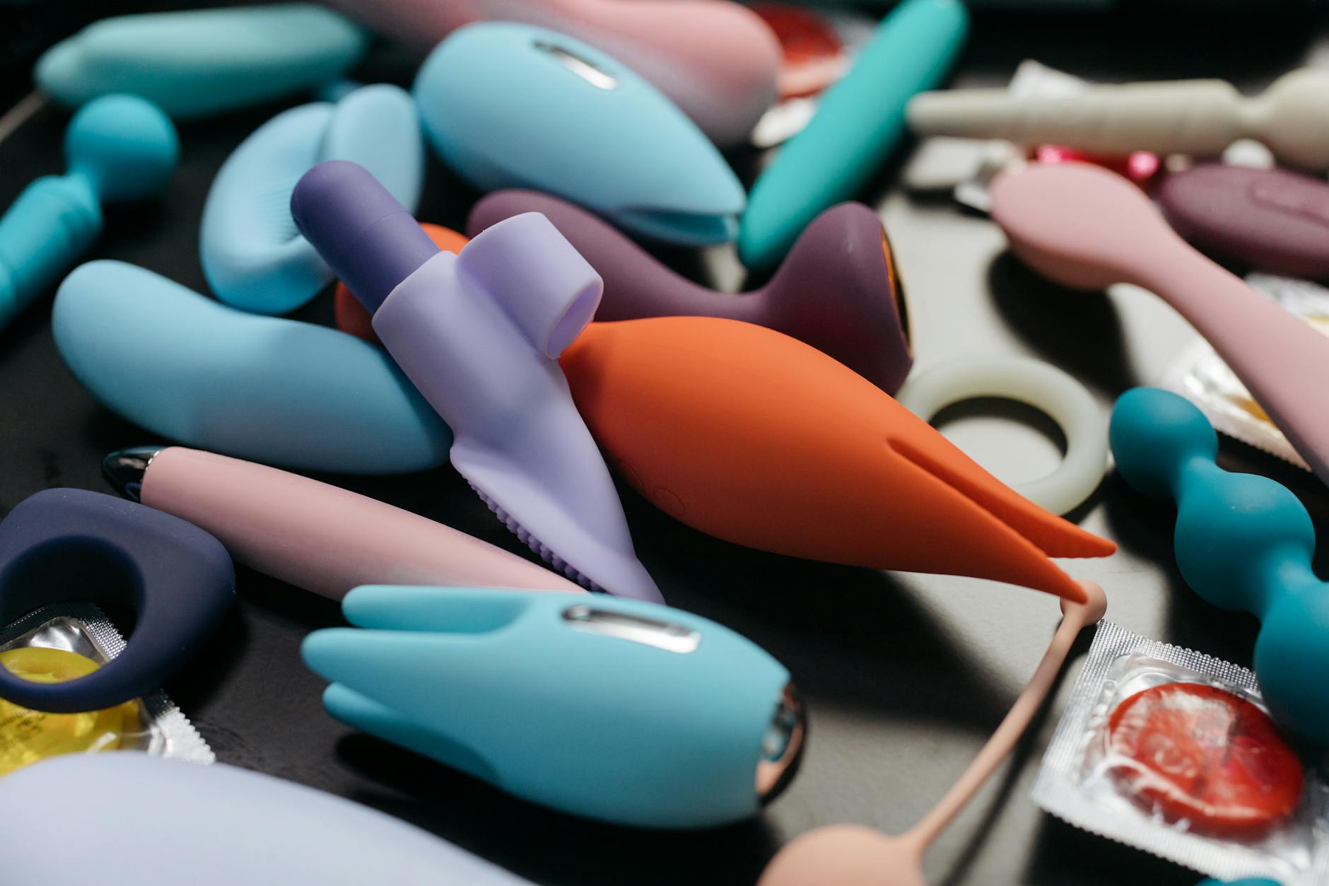 A person holding a basket containing colorful vibrators and a pink flower